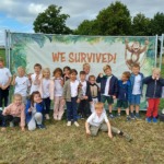 Alt tekst: Blije kinderen voor de 'We Survived!' banner na avontuurlijk dagje.