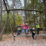 Kinderen spelen op een touwbrug in bos, op kleinschalig avonturenpark De Vuurvogel.